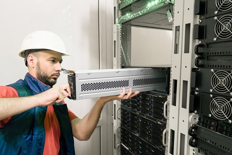 Un ingeniero reemplaza una batería en un SAI